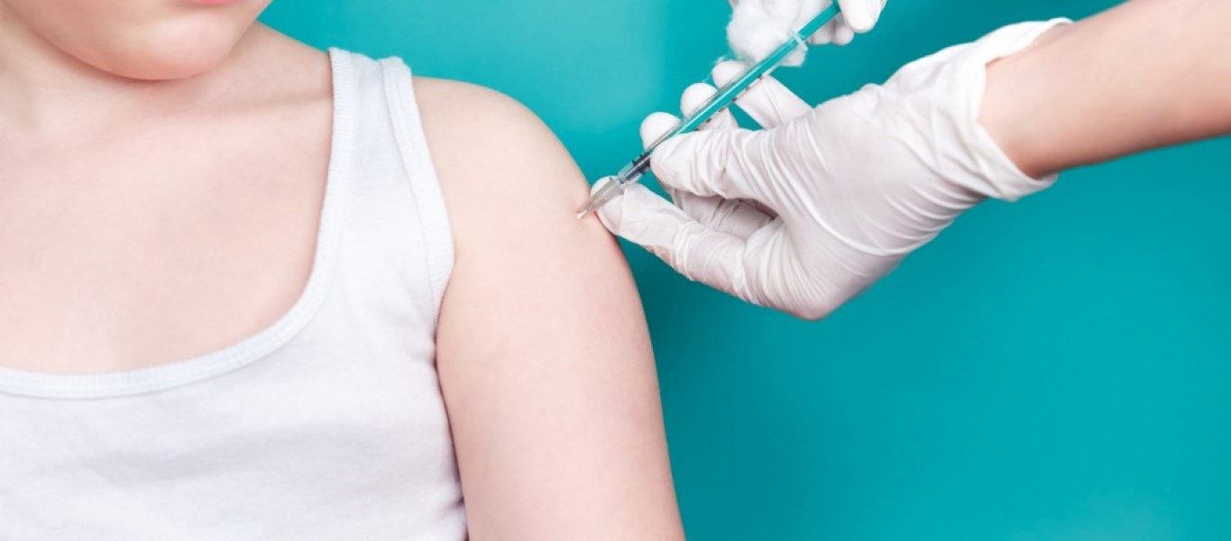 Doctor makes vaccination to a child. Inoculation in the shoulder